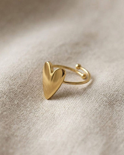 Close-up of the adjustable Lily Heart ring on soft fabric, highlighting its polished gold surface and delicate heart detail.