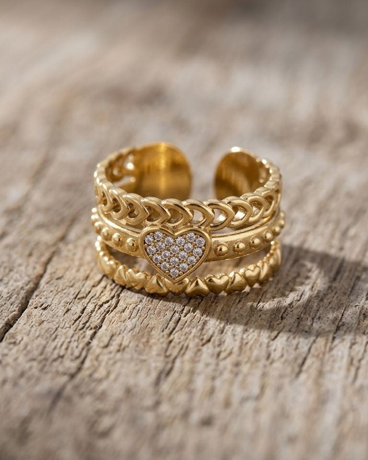Close-up of a delicate Dainty Heart Chain ring with crystalline rhinestones on a natural wood surface, highlighting the intricate multi-layered heart motif.