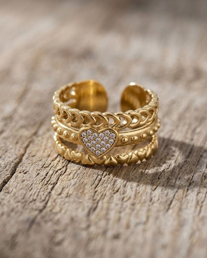 Close-up of a delicate Dainty Heart Chain ring with crystalline rhinestones on a natural wood surface, highlighting the intricate multi-layered heart motif.