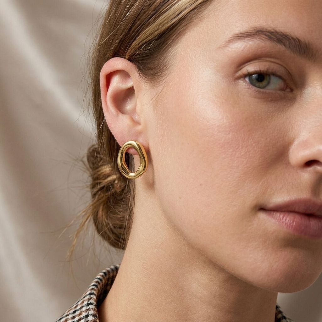 Close-up of Organic Wave Studs earrings showcasing their sculptural wave form and shiny stainless steel texture.
