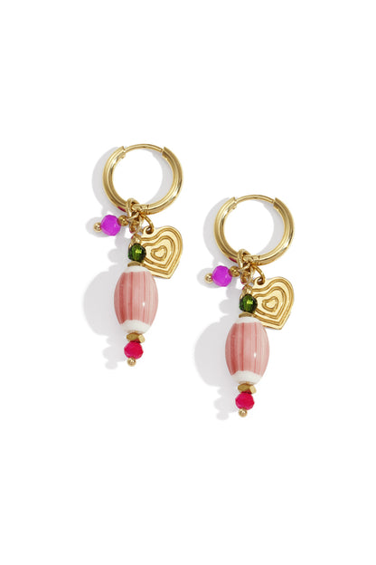 Pair of gold-tone hoop earrings featuring striped pink oval beads, gold heart charms, and fuchsia and green crystal accents on a white background