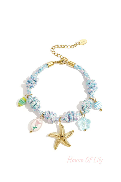 Blue and pastel twisted rope charm bracelet featuring a golden starfish pendant with floral and striped glass charms