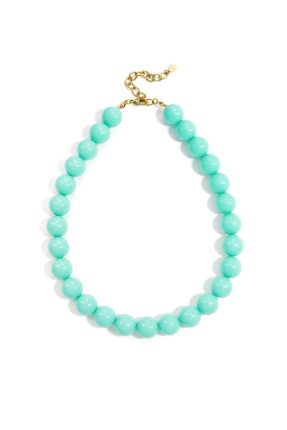 Chunky necklace featuring vibrant turquoise beads and a gold-tone metal clasp, isolated on a white background.
