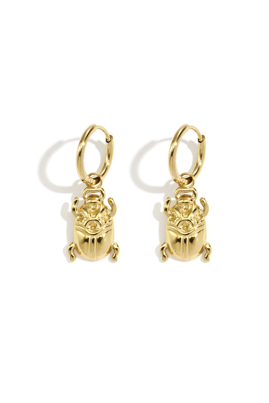 Pair of polished gold bug-shaped drop earrings with hoop fastenings displayed on white background