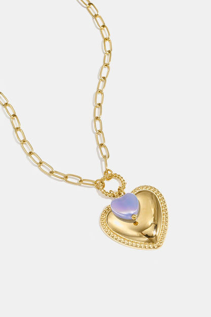 Gold chain necklace featuring a layered heart pendant with a metallic gold base and small iridescent lavender heart.