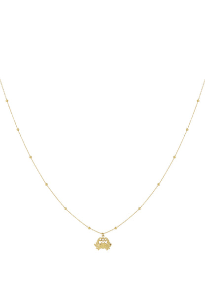 Gold crab charm necklace with fine beaded chain on white background