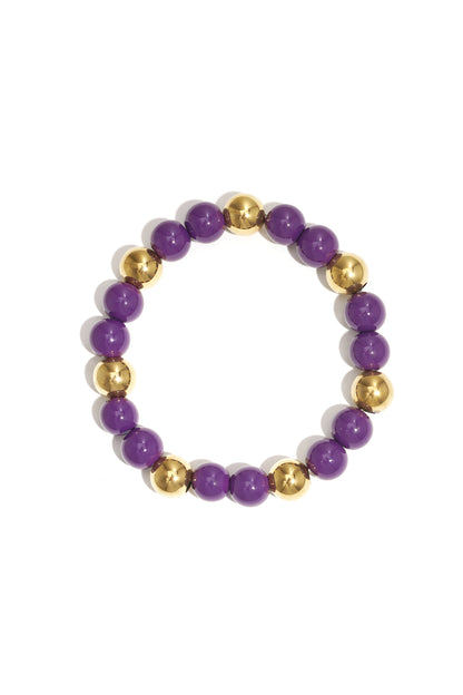 Single acrylic beaded bracelet featuring alternating purple and gold-tone beads isolated on white background