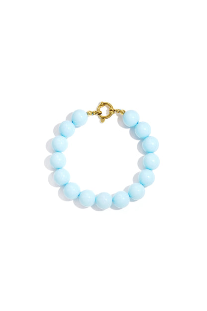 Vibrant light blue round resin beads on a gold-tone spring ring clasp bracelet against a white background.