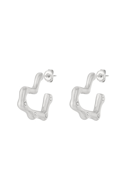 Silver wavy hoop earrings with rhinestone accents displayed on a white background