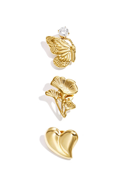 Three gold-tone brooches displayed on white background: butterfly with rhinestone, floral sprig, and heart shape.