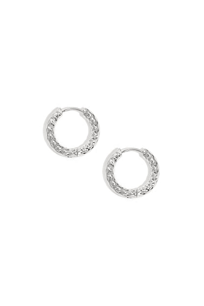 Pair of textured silver hoop earrings on white background showing hammered metal design