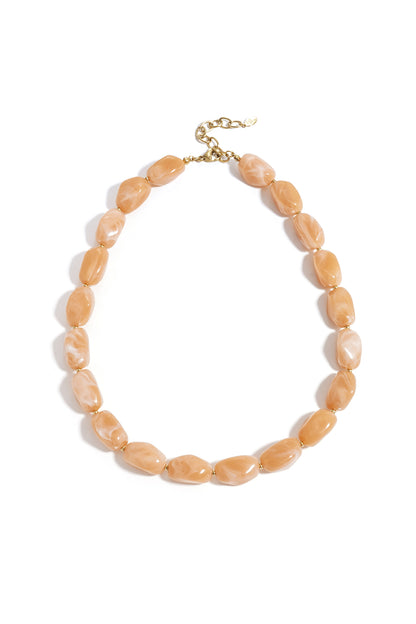Light peach chunky beaded necklace with gold spacers and lobster clasp on white background