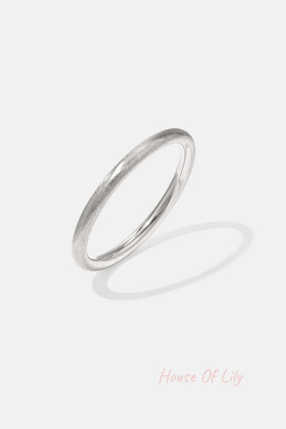 Silver minimalist bangle bracelet with a brushed texture on white background