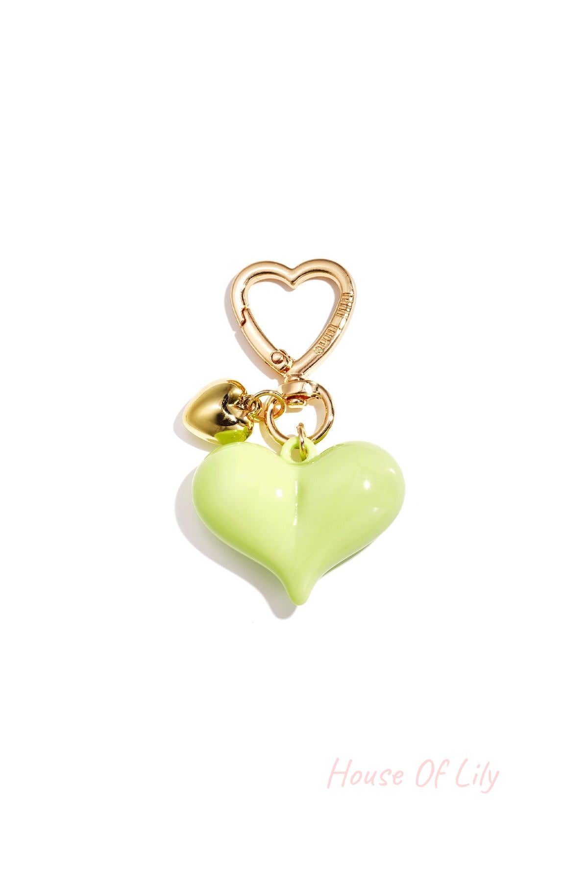 Single green heart acrylic bag charm with gold heart clasp and mini gold heart pendant on white background