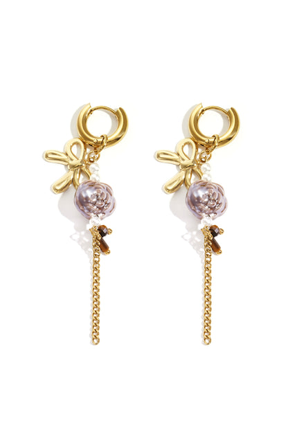 Pair of gold-tone floral drop earrings featuring bow motifs, purple flower beads, faux pearls, and dangling gold chains on white background