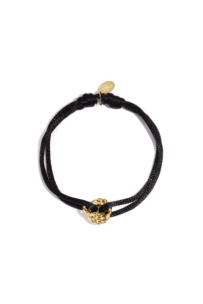 Vibrant Knot Charm Bracelet with a black cord and a gold twisted knot charm on a white background.