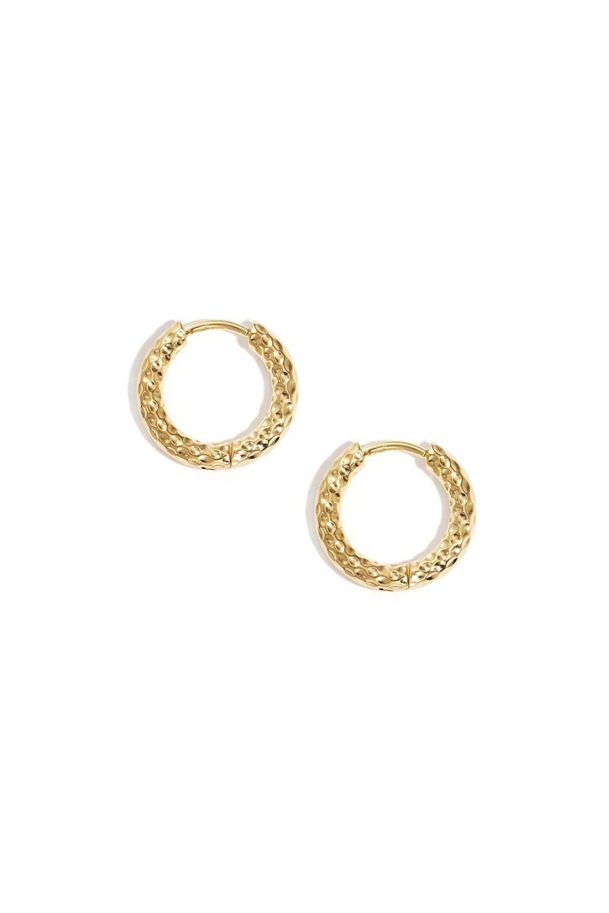 Pair of textured gold hoop earrings on white background showing hammered metal design