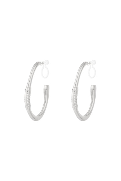 Pair of silver textured hoop clip-on earrings on white background