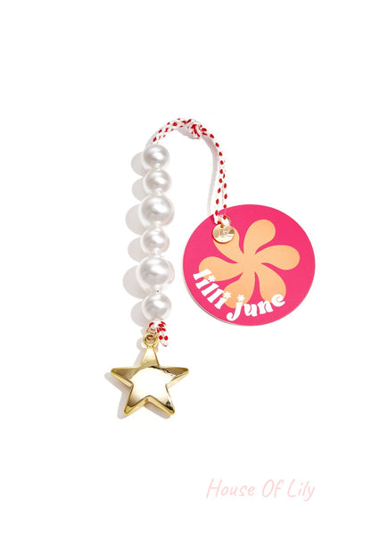 Pearl star bag charm with a pink and orange Lilli June brand tag; white acrylic beads and gold star pendant on a white background