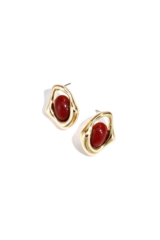 Pair of gold-tone stud earrings with irregular shapes featuring deep red oval stones centered within a glossy finish