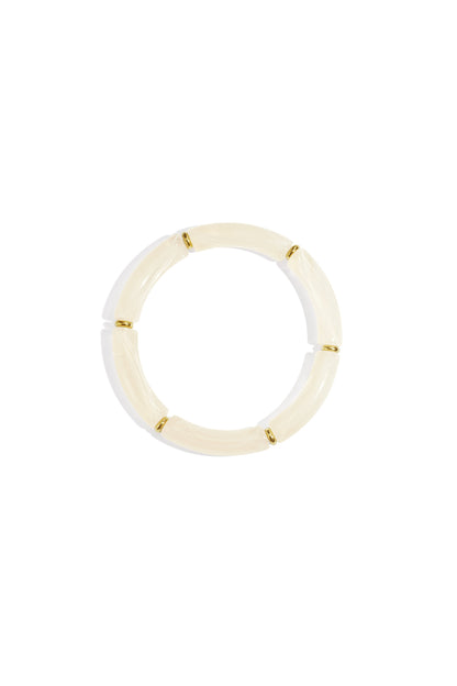 Cream ivory resin tube bracelet with gold-tone ring spacers on white background