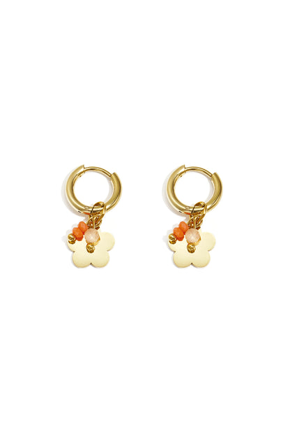 Pair of gold-plated hoop earrings with flower-shaped charm and orange-beige beads on white background