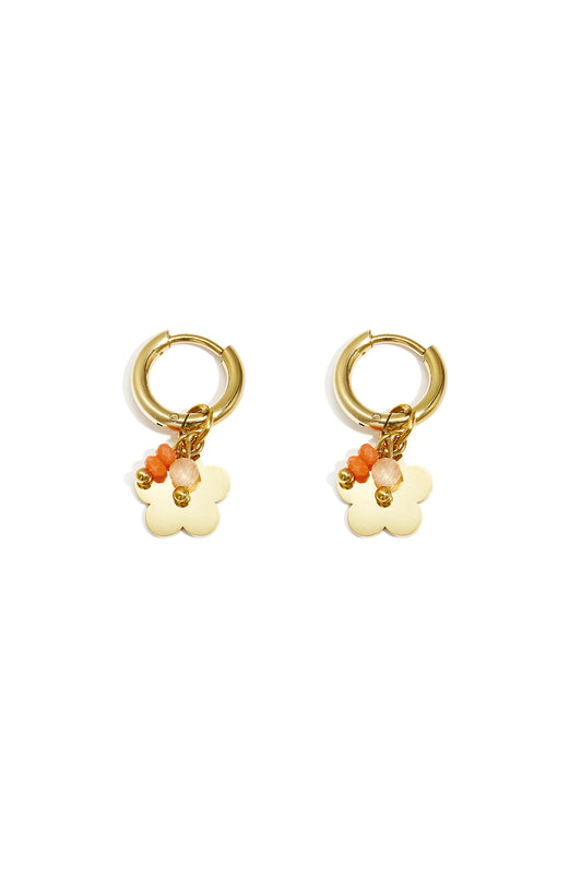 Pair of gold-plated hoop earrings with flower-shaped charm and orange-beige beads on white background