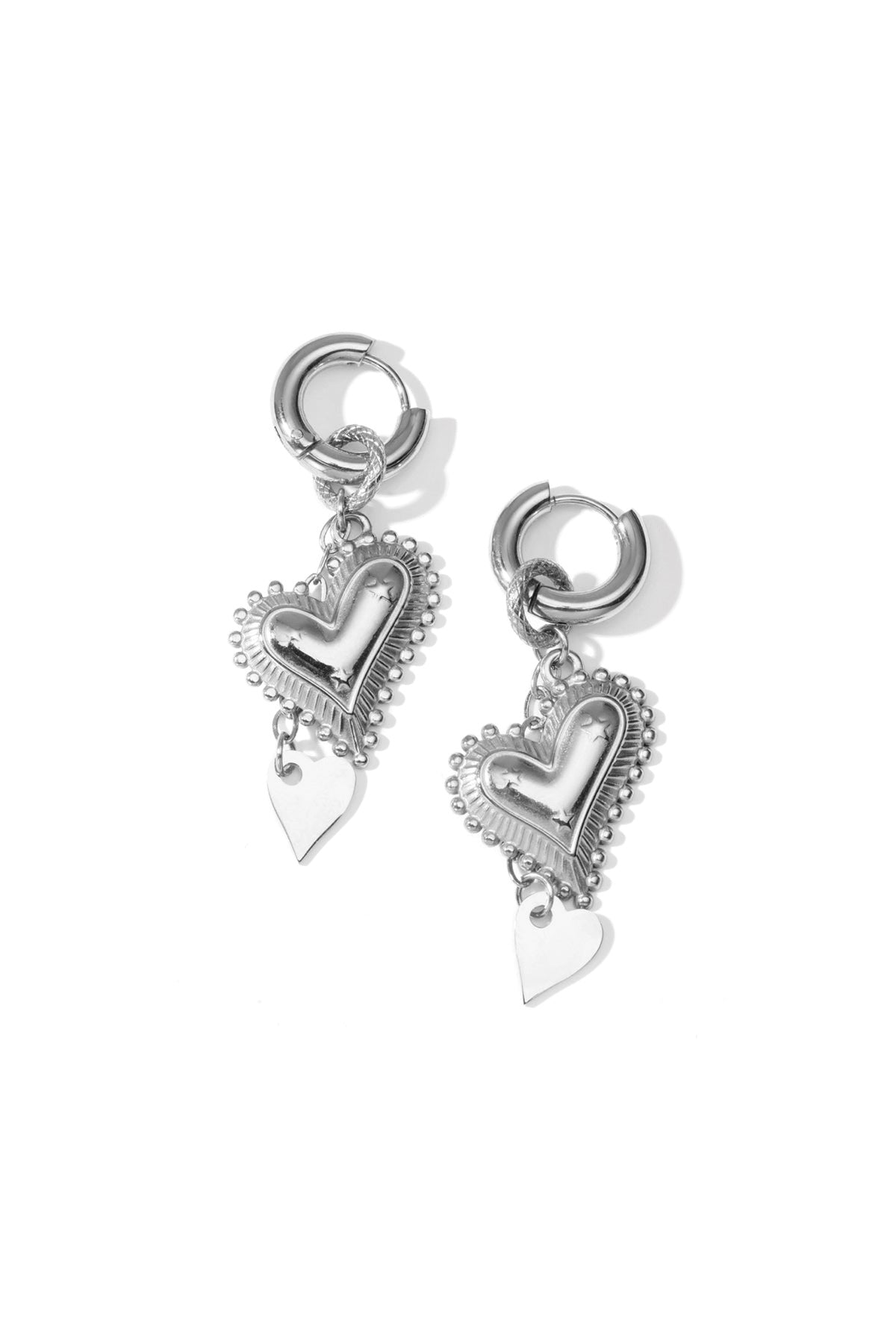 Silver heart drop earrings with embossed larger heart and smaller dangling heart displayed on a white background