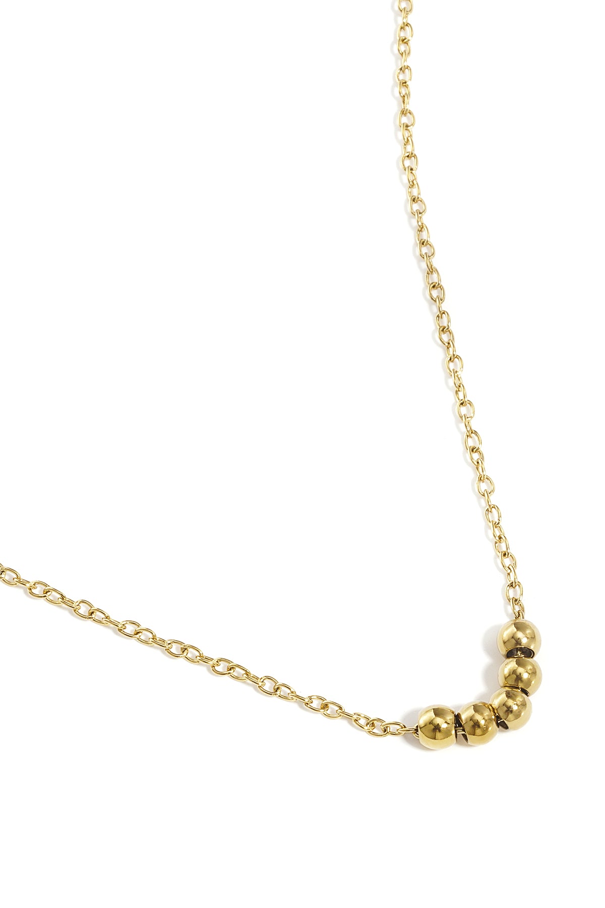 Close-up of gold ball chain necklace showing five smooth ball beads on a fine chain