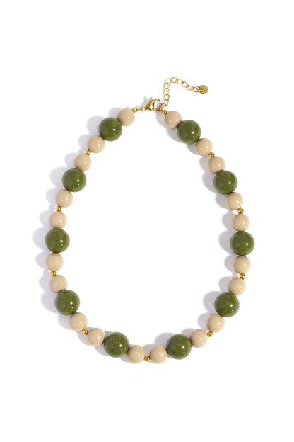 Chunky beaded necklace with alternating green and cream acrylic beads and gold clasp on white background