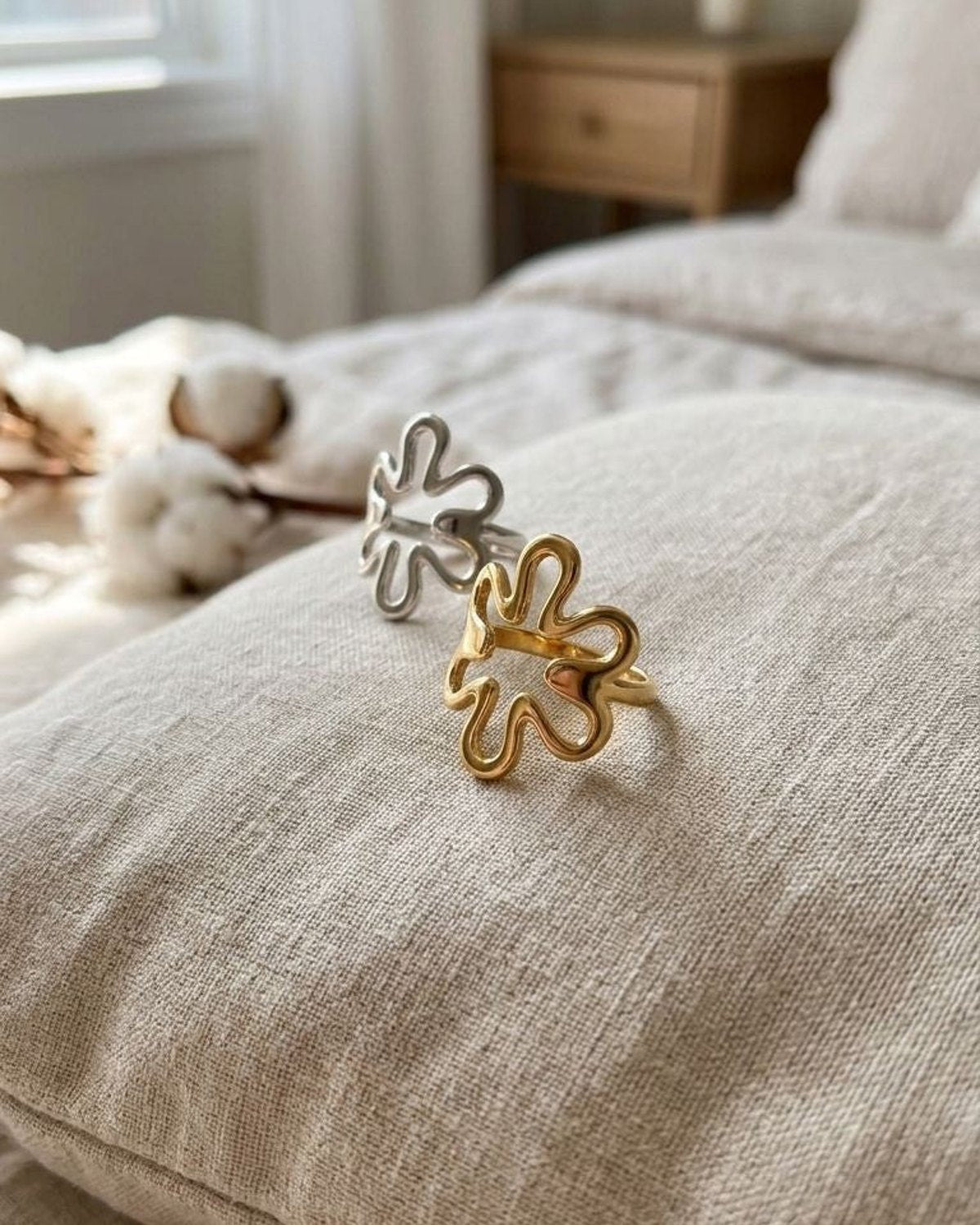 Close-up of the Dainty Floral Outline ring on a velvet cushion, highlighting its delicate floral design and polished metal finish.