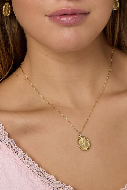 Close-up detail of gold tulip blossom pendant necklace on model's neck