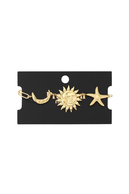 Gold chain bracelet featuring celestial charms: a crescent moon, a face-engraved sun, and a textured starfish.