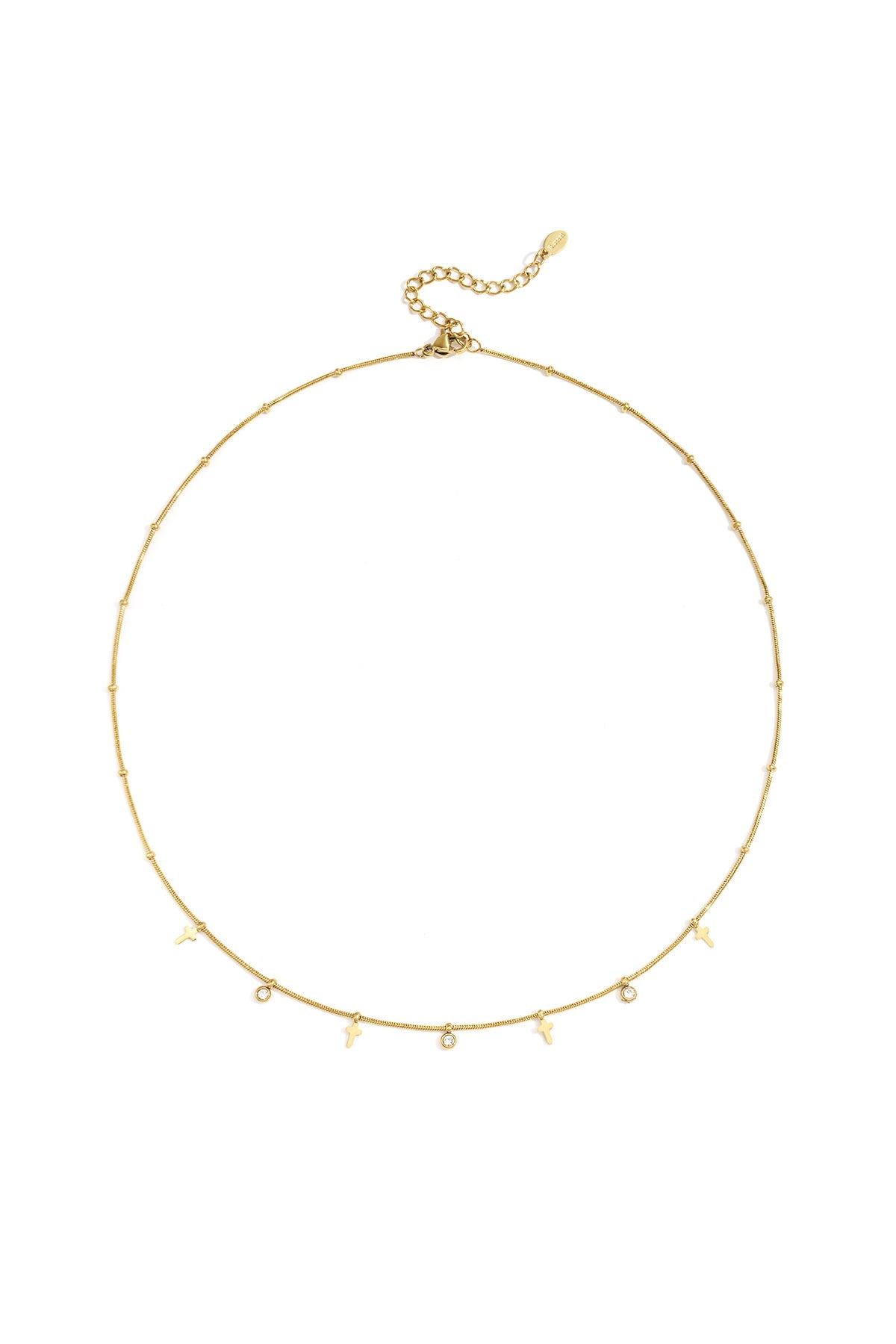 Gold cross necklace with rhinestone charms laid flat on white background