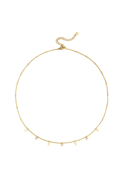 Gold cross necklace with rhinestone charms laid flat on white background