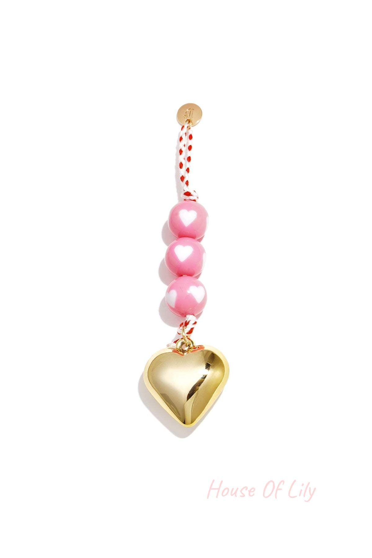 Rose pink heart charm bag keychain with white heart patterned beads and gold heart pendant on braided red cord