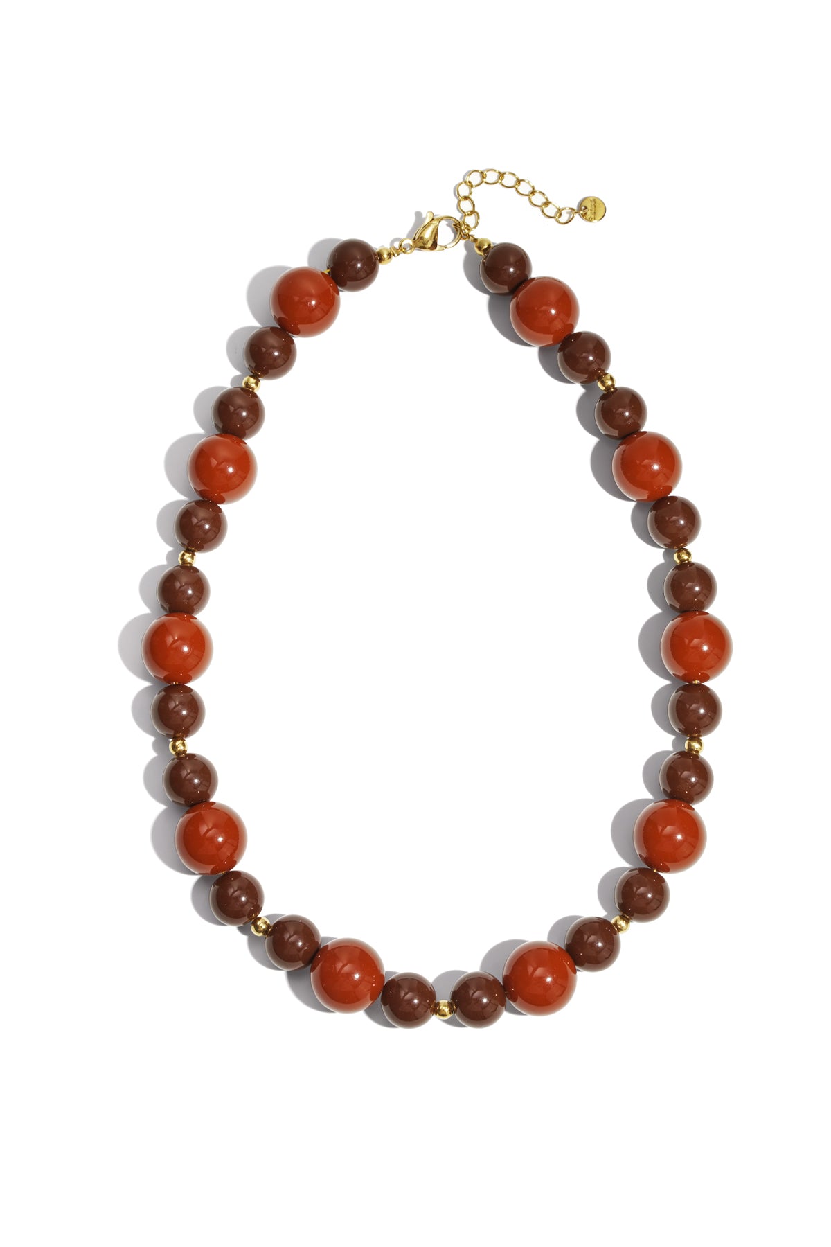 Chunky beaded necklace featuring shades of purple, violet, and light pink beads with gold accents on white background