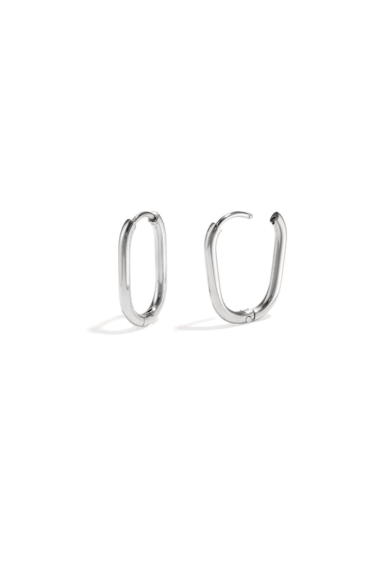 Pair of polished silver oval hoop earrings with snap closure on white background