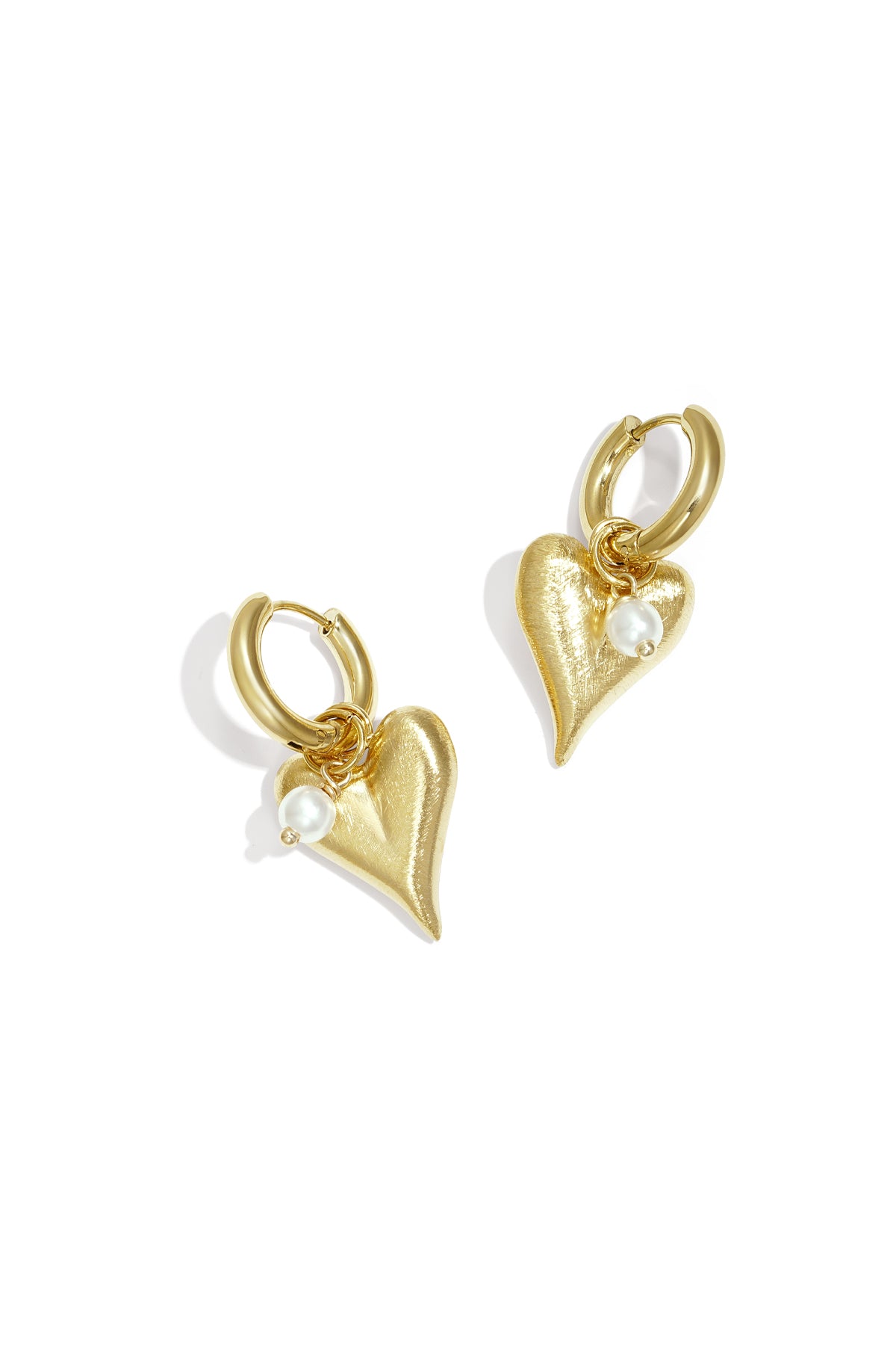 Pair of gold heart charm hoop earrings with pearl detail on white background