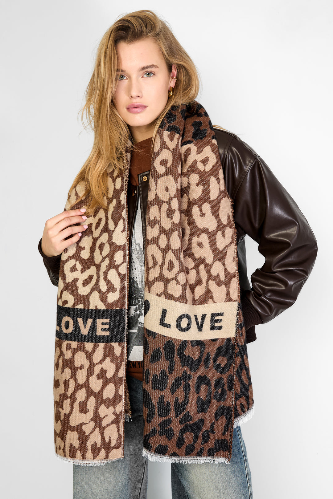 Woman wearing a large leopard print scarf draped over her shoulders paired with casual outfit