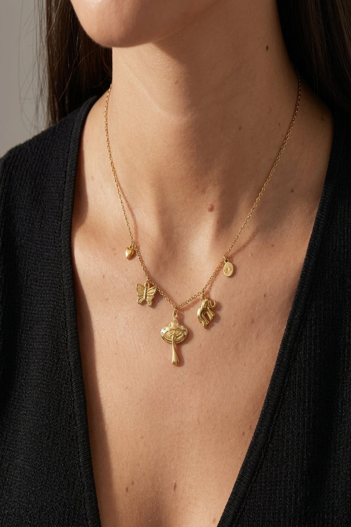 Close-up of a petite angel energy charm necklace with rhinestones and a small heart, highlighting delicate craftsmanship and sparkle.