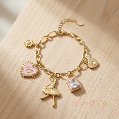 Tiny charm bracelet with colorful dancer charms on wooden surface, highlighting its dainty design and craftsmanship.
