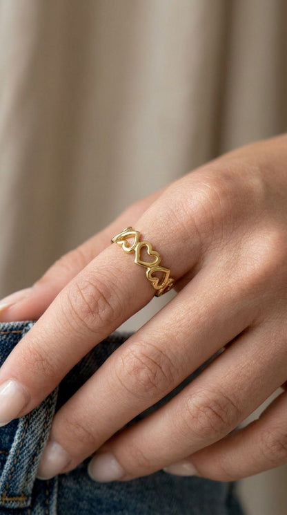 Close-up of the small stainless steel little heart ring with a shiny finish on a slim finger.