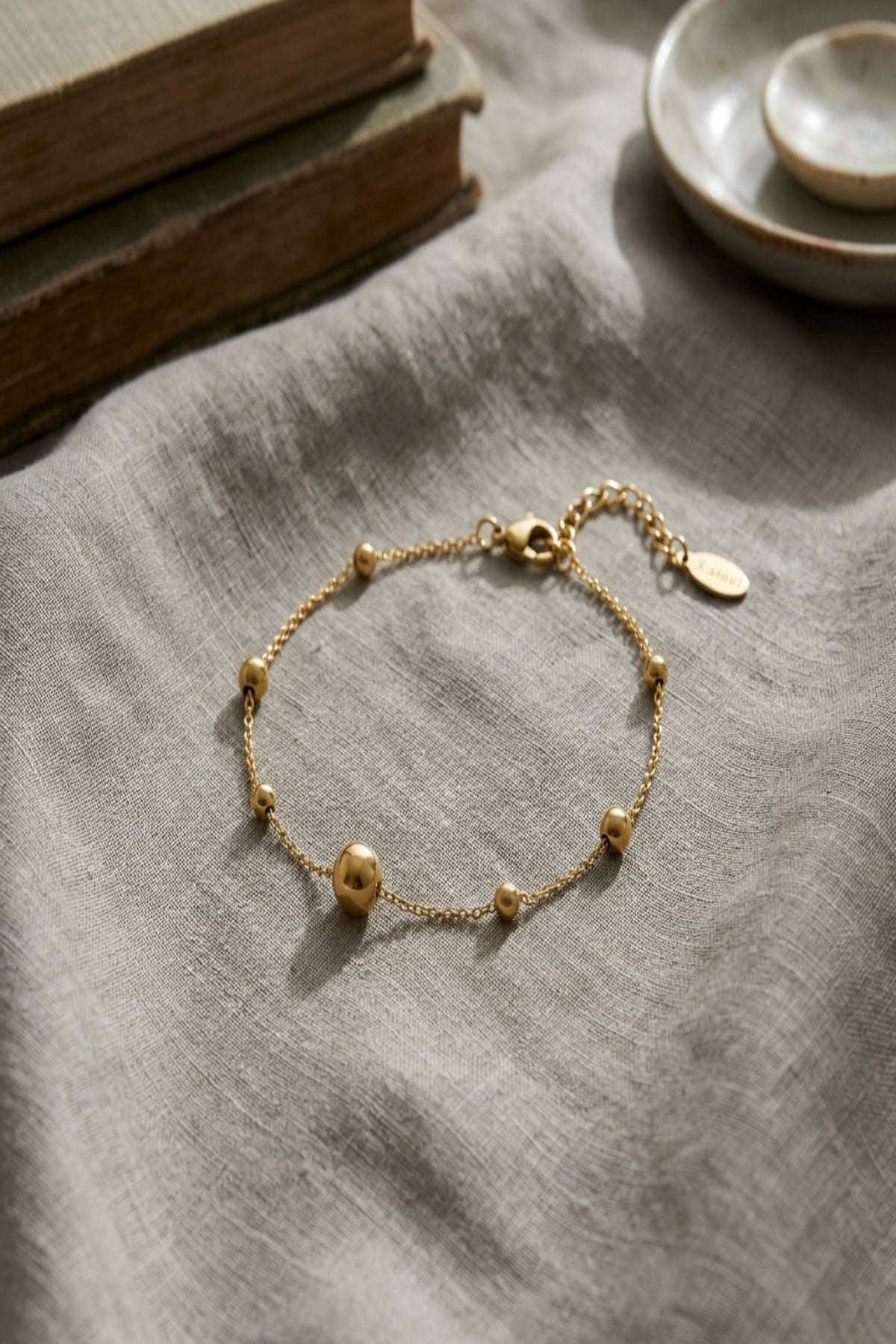 Close-up of the stainless steel bracelet highlighting its thin chain and lobster clasp with subtle reflections.
