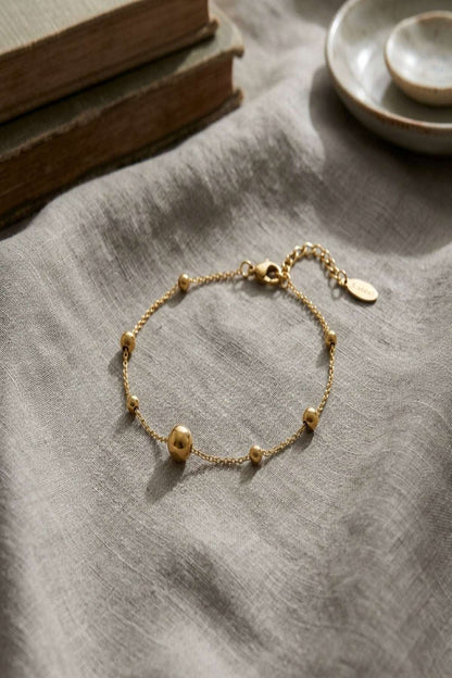 Close-up of the stainless steel bracelet highlighting its thin chain and lobster clasp with subtle reflections.