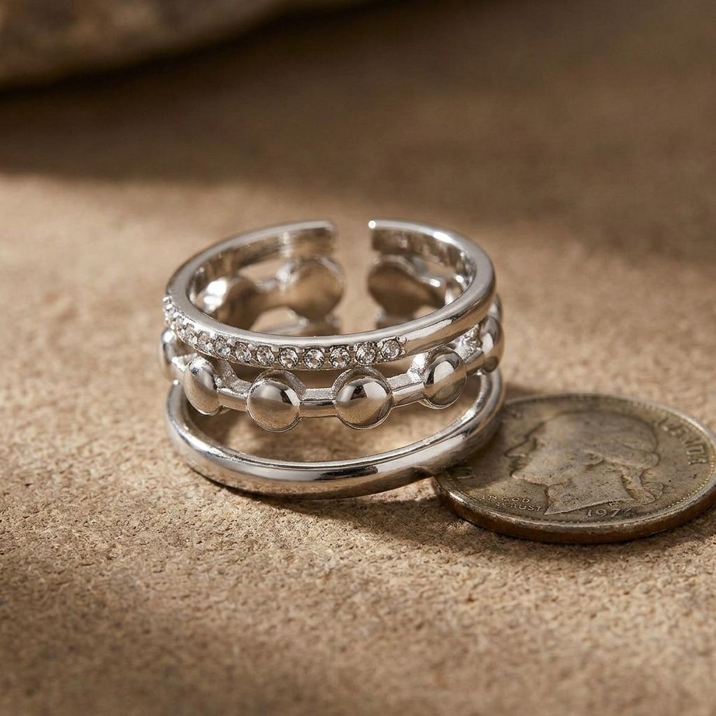 Close-up of layered Triple Tier Sparkle Ring with rhinestones on textured surface, highlighting its elegance and irregular shape.