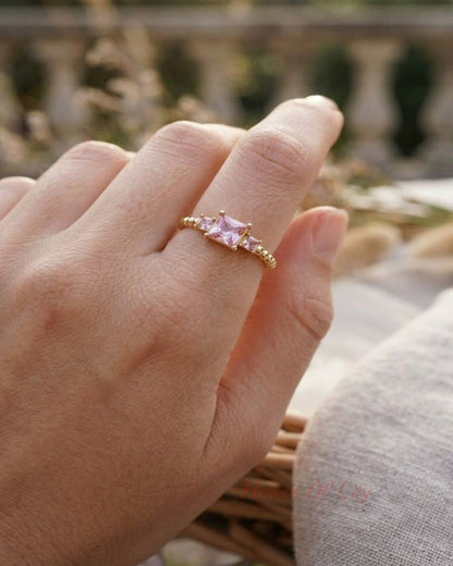 Y2K Square Gem gold ring on a slender finger in an outdoor setting, showcasing its geometric silhouette and subtle elegance.