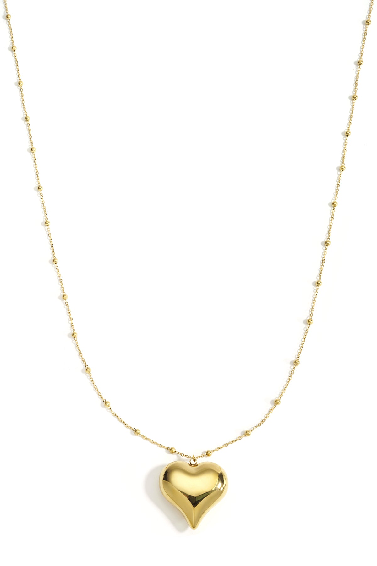 Gold long necklace with polished heart pendant and small bead details on chain, displayed on white background