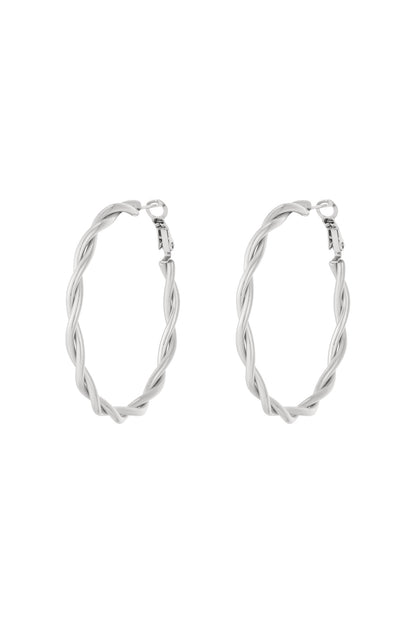 Flat lay of gold twisted oval hoop earrings with latch back closures on white background