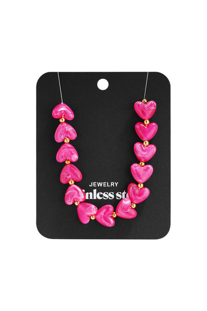Light orange marbled heart bead necklace with gold spacers on white background